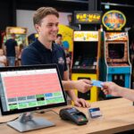 Arcade-Kassensystem: Mitarbeiter verkaufen und laden eine Spielkarte an der Rezeption einer Spielhalle auf