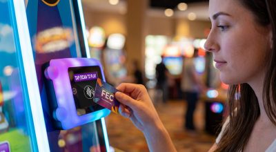 Arcade card system: guest tapping a rechargeable game card on an arcade machine card reader